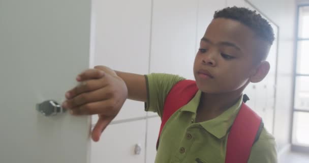 非洲裔美国男孩关闭储物柜和微笑在学校的视频 小学教育 知识和学习概念 — 图库视频影像