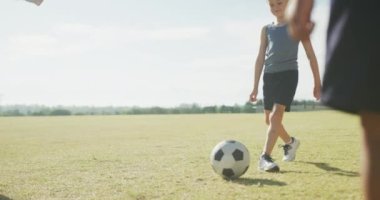 Spor sahasında futbol oynayan çeşitli çocukların bacakları. İlkokul eğitimi, spor ve egzersiz.