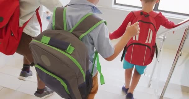 学校で階下を歩いている白人の少年の後ろのビデオ 小学校教育知識学習の概念 — ストック動画