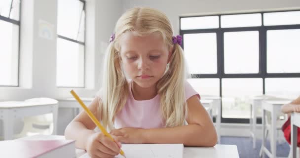 Nagranie Szczęśliwej Białej Dziewczyny Siedzącej Przy Szkolnym Biurku Uczącej Się — Wideo stockowe