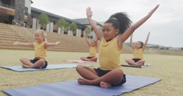 在学校门前 不同性别的女孩在床垫上练习瑜伽的视频 小学教育 体育和运动概念 — 图库视频影像