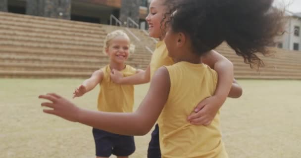 学校の前でサッカーの試合の後に抱きつく多様な女の子の足のビデオ 小学校教育 スポーツ 運動の概念 — ストック動画