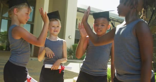 Video Van Gelukkige Diverse Jongens Gooien Hoeden Afstuderen Basisonderwijs Afstudeerconcept — Stockvideo