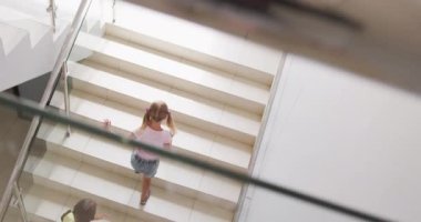 Üst kattaki okullarda yürüyen farklı kızların videosu. İlköğretim, öğrenme ve sosyalleştirme kavramı.