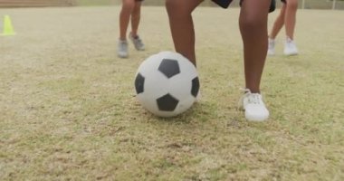 Okulun önünde futbol oynayan farklı çocukların bacakları. İlkokul eğitimi, spor ve egzersiz konsepti.