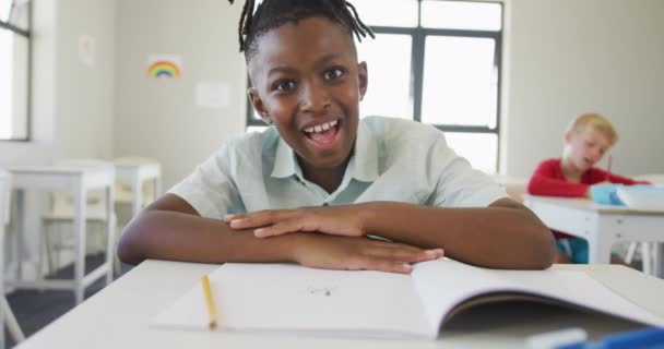 Βίντεο Του Χαρούμενου Αφροαμερικανού Αγοριού Που Κάθεται Στο Γραφείο Του — Αρχείο Βίντεο