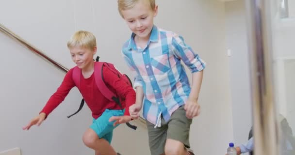学校で二階に走っている幸せな白人の少年のビデオ 小学校教育知識学習の概念 — ストック動画