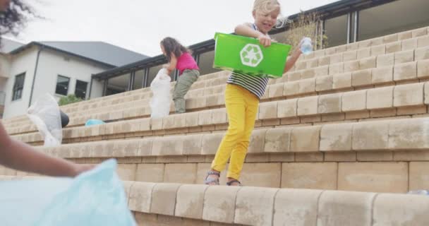 学校の前でゴミを掃除している様々な女の子たちの映像 小学校教育生態環境ボランティアの概念は — ストック動画