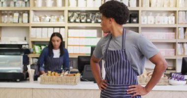 Animation of happy biracial waiter standing in coffee shop. coffee and bistro shop, running small independent business.
