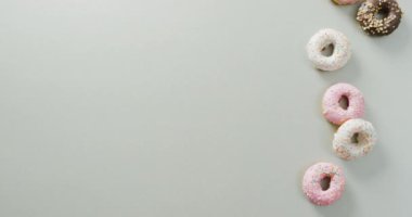Beyaz arka planda kremalı donut videosu. Renkli yemek, şeker, abur cubur ve tatlı konsepti.