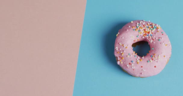 蓝色和粉色背景上结冰的甜甜圈视频 五彩缤纷的食物 小吃和糖果概念 — 图库视频影像