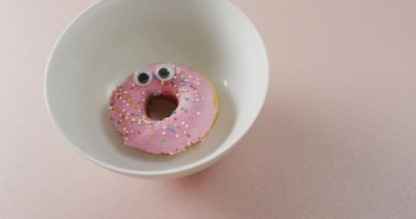 在粉红的背景上 甜甜圈与白盘结冰的视频 五彩缤纷的食物 小吃和糖果概念 — 图库视频影像
