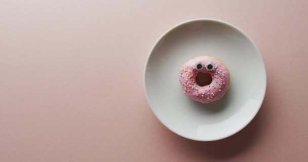 Video Von Donut Mit Sahnehäubchen Auf Weißem Teller Auf Rosa — Stockvideo