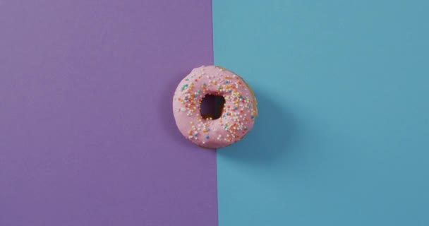 Video Von Donut Mit Sahnehäubchen Auf Lila Und Blauem Hintergrund — Stockvideo