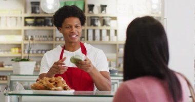 Kadın müşterilere yemek satan mutlu çift ırklı garsonun animasyonu. Kahve ve fil dükkanı, küçük bağımsız işler yürütüyor..