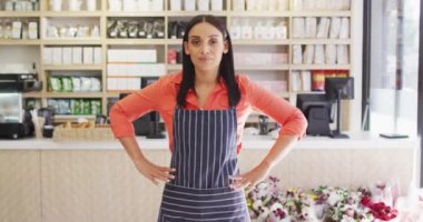 Kafede duran önlüklü mutlu melez garsonun videosu. Kahve ve fil dükkanı, küçük bağımsız işler yürütüyor..