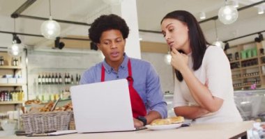 Kafede dizüstü bilgisayarla çalışan çeşitli kadın ve erkek garsonların videoları. Kahve ve fil dükkanı, küçük bağımsız işler yürütüyor..