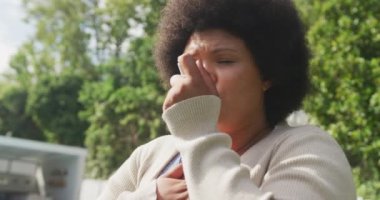 Açık havada astım spreyi kullanan Afro-Amerikan bir kadının videosu. Sağlık ve astım farkındalığı kavramı.