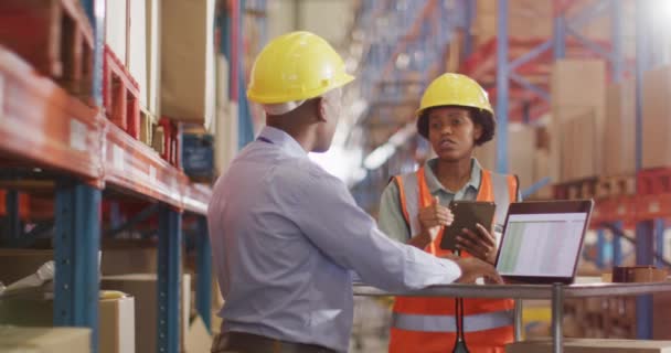 Αφροαμερικανοί Εργάτες Που Φοράνε Κράνος Και Χρησιμοποιούν Λάπτοπ Στην Αποθήκη — Αρχείο Βίντεο