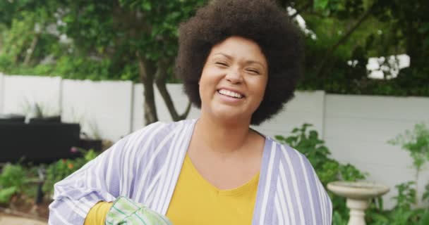 Film Szczęśliwy Size Afrykańska Amerykanka Podlewanie Kwiatów Ogrodzie Styl Życia — Wideo stockowe