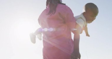 Mutlu Afro-Amerikan baba ve oğlunun güneşli bir günde eğlendiği bir video. Aile, birliktelik, birlikte dışarıda kaliteli zaman geçirmek..