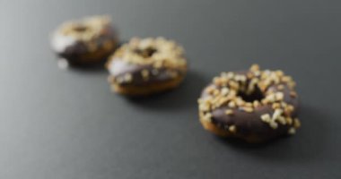 Gri arka planda çikolatalı donut videosu. Renkli yemek, şeker, abur cubur ve tatlı konsepti.