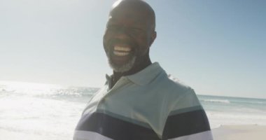 Sunny Beach 'te gülümseyen yaşlı Afro-Amerikan bir adamın portresi. sağlıklı, aktif emeklilik plaj tatili.