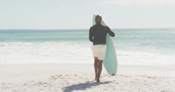 Hombre Afroamericano Mayor Caminando Con Tabla Surf Playa Soleada Saludable — Vídeos de Stock