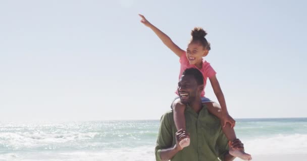 Smiling African American Father Carrying His Daughter Sunny Beach Healthy — Vídeo de stock