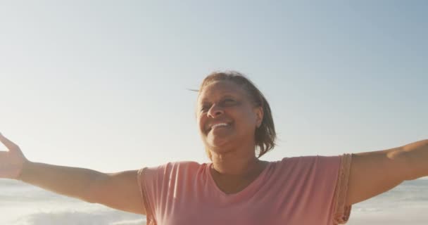 Sorridente Anziana Donna Afroamericana Con Braccia Larghe Sulla Spiaggia Soleggiata — Video Stock
