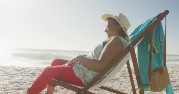 一位面带微笑的资深非洲裔美国女人躺在阳光普照的海滩上的画像 积极的退休海滩假期 — 图库视频影像