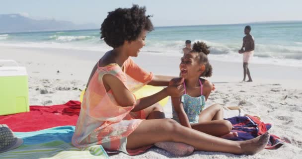 Famiglia Afro Americana Sorridente Che Usa Crema Solare Sulla Spiaggia — Video Stock