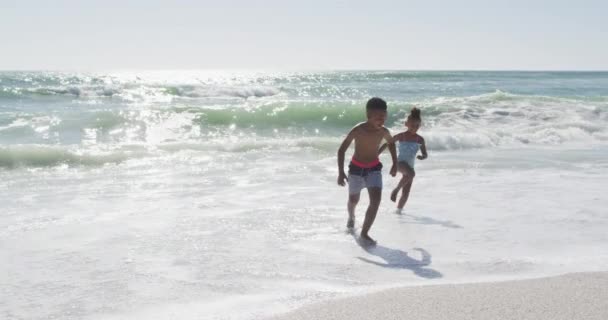 Smiling African American Siblings Running Wearing Swimming Suits Sunny Beach — Vídeo de Stock