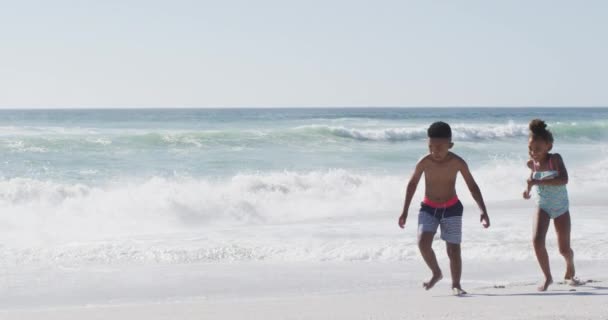 Smiling African American Siblings Running Wearing Swimming Suits Sunny Beach — Vídeo de Stock
