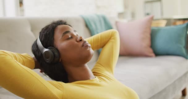 Vídeo Uma Mulher Afro Americana Relaxada Usando Fones Ouvido Sentada — Vídeo de Stock