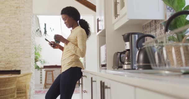 Video African American Woman Drinking Coffee Using Smartphone Kitchen Leisure — Stockvideo