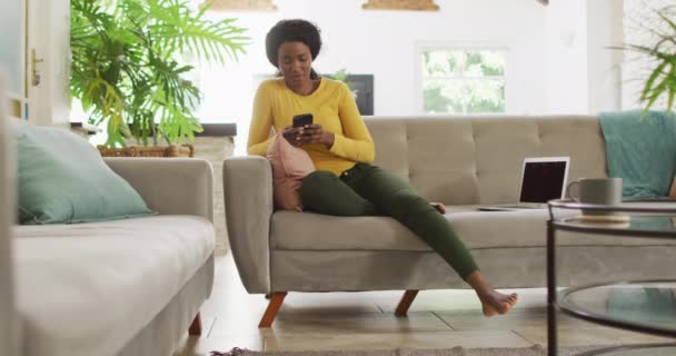 Vídeo Mulher Americana Africana Feliz Sofá Usando Smartphone Lazer Relaxar — Vídeo de Stock