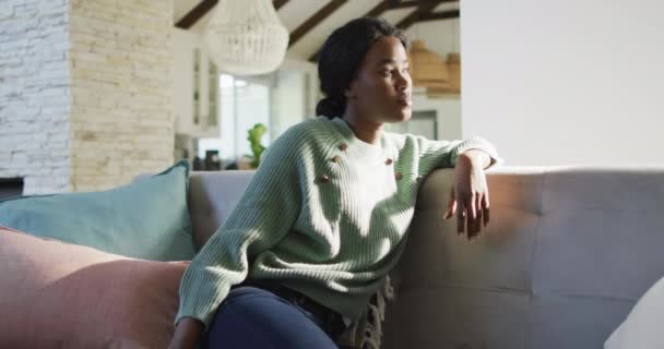 Βίντεο Μια Σκεπτόμενη Αφροαμερικανή Κάθεται Στον Καναπέ Και Κοιτάει Έξω — Αρχείο Βίντεο