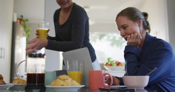 家庭で朝食をとりながらノートパソコンでビデオ通話をしている白人レズビアンカップル Lgbt関係とライフスタイルの概念 — ストック動画