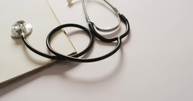 Pembe arka planda steteskoplu yakın çekim videosu. küresel tıp ve sağlık konsepti.