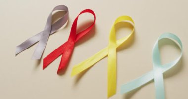 Beyaz arka planda kanserli kurdelelerin yakın çekim videosu. küresel tıp ve sağlık konsepti.