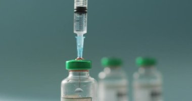Video of close up of vaccine vials on green background. global medicine and healthcare concept.