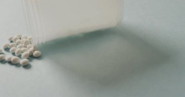 Beyaz arka planda beyaz hapların olduğu kutuyu kapatma videosu. küresel tıp ve sağlık konsepti.