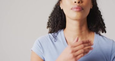 Beyaz arka planda boynuna dokunan melez kadının videosu. küresel tıp ve sağlık konsepti.