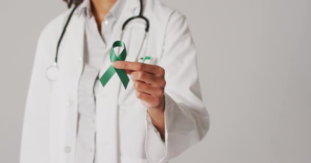Video biraciální doktorky držící smaragdovou stužku na rakovinu jater. globální medicína a koncept zdravotní péče. 