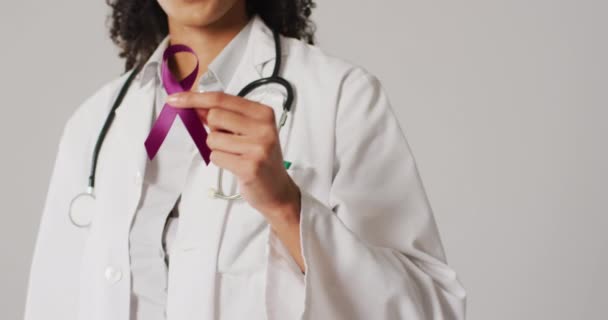 Video Smiling Biracial Female Doctor Holding Purple Pancreatic Cancer Ribbon — стоковое видео