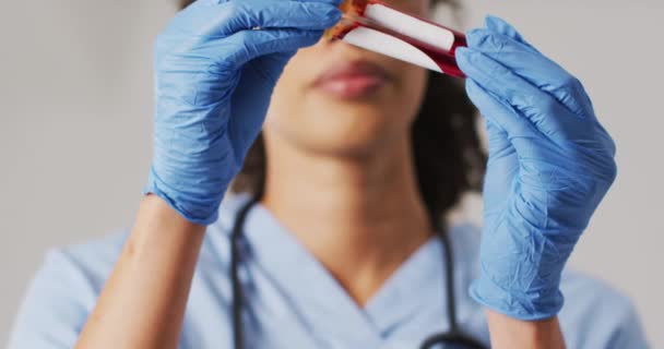 Video Biracial Female Doctor Holding Test Tube Blue Background Global — Stok video