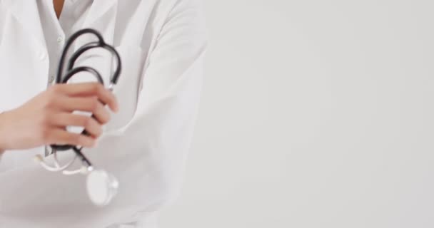 Video Biracial Female Doctor Holding Stethoscope White Background Global Medicine — стоковое видео
