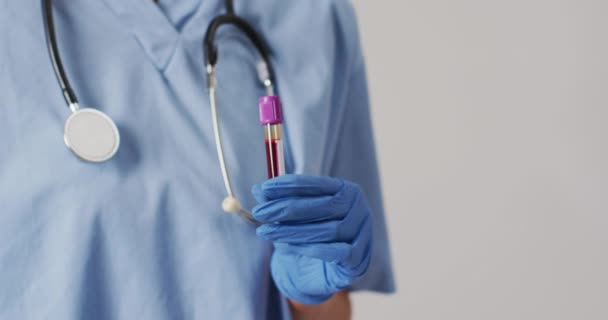 青色の背景に試験管を保持出産女性医師のビデオ 世界的な医療とヘルスケアの概念 — ストック動画