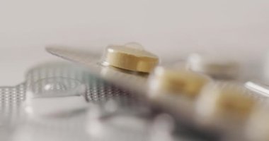 Pembe arka planda sarı tabletlerin yakın çekim videosu. küresel tıp ve sağlık konsepti.